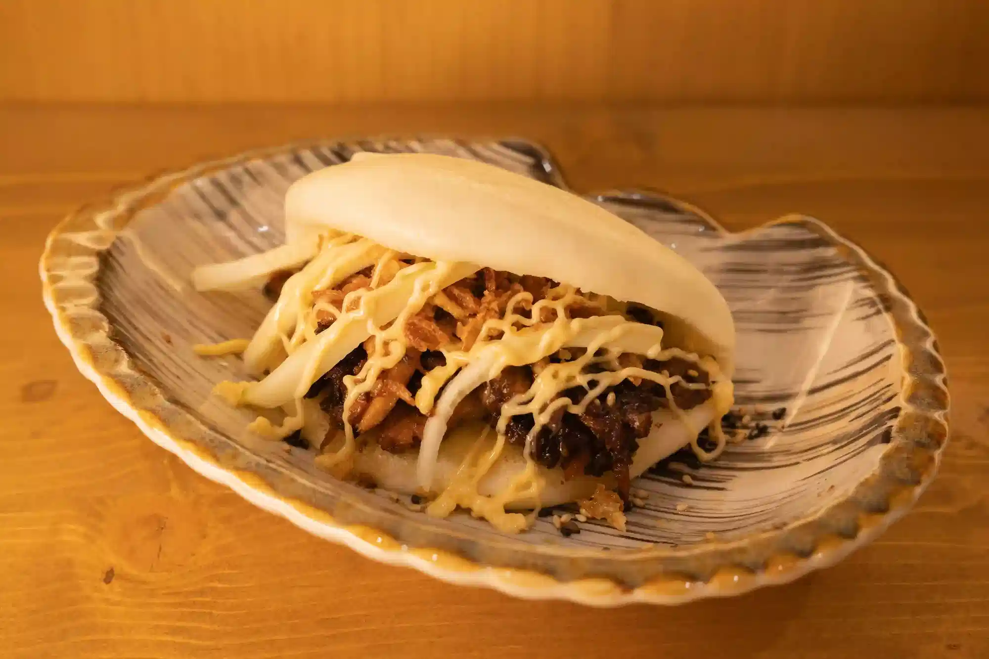 esponjoso pan bao relleno de chashu marinado al estilo japonés disponible en Ryu Ramen García nuevo restaurante de ramen en Poblenou Barcelona